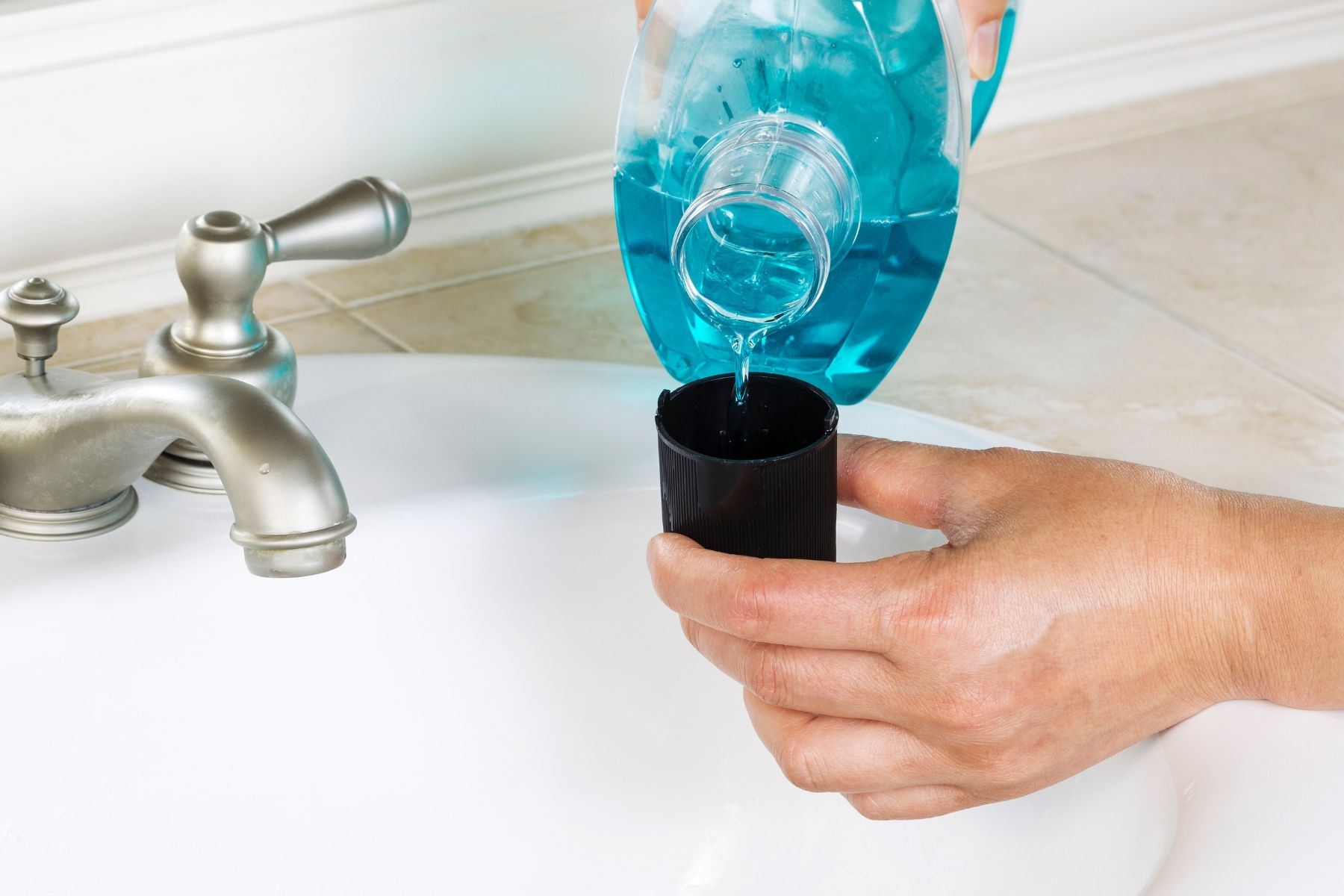 Bạn có thể dùng nước súc miệng nha khoa để kiểm soát và làm giảm các triệu chứng viêm, nhiễm trùng do nhiệt miệng (Nguồn: Canva)